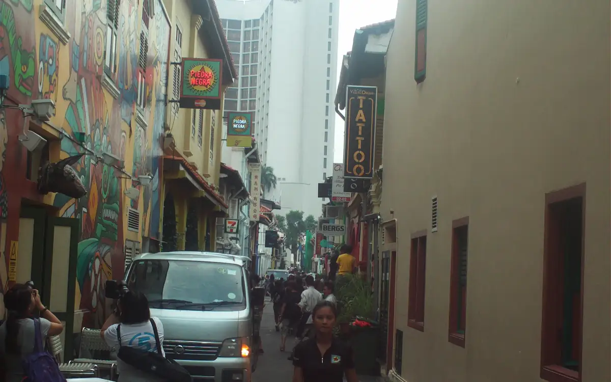 Haji Lane in Kampong Glam, with colourful shophouses, signboards and a street of pedestrians and traffic