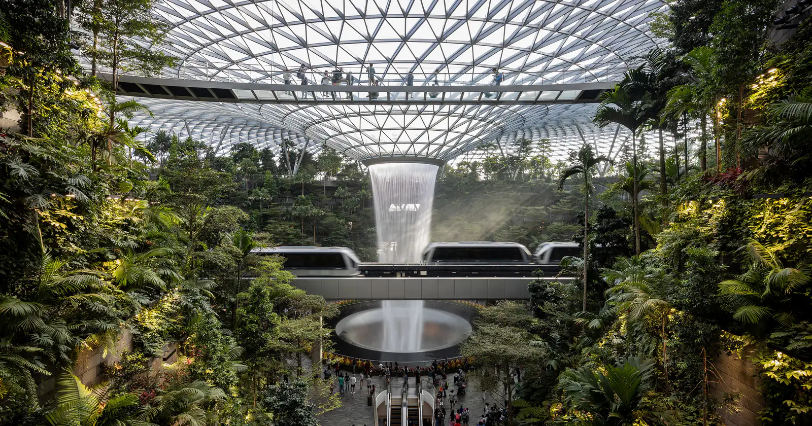 Rain Vortex waterfall inside Jewel Changi Airport, with the glass canopy and garden courtyard below